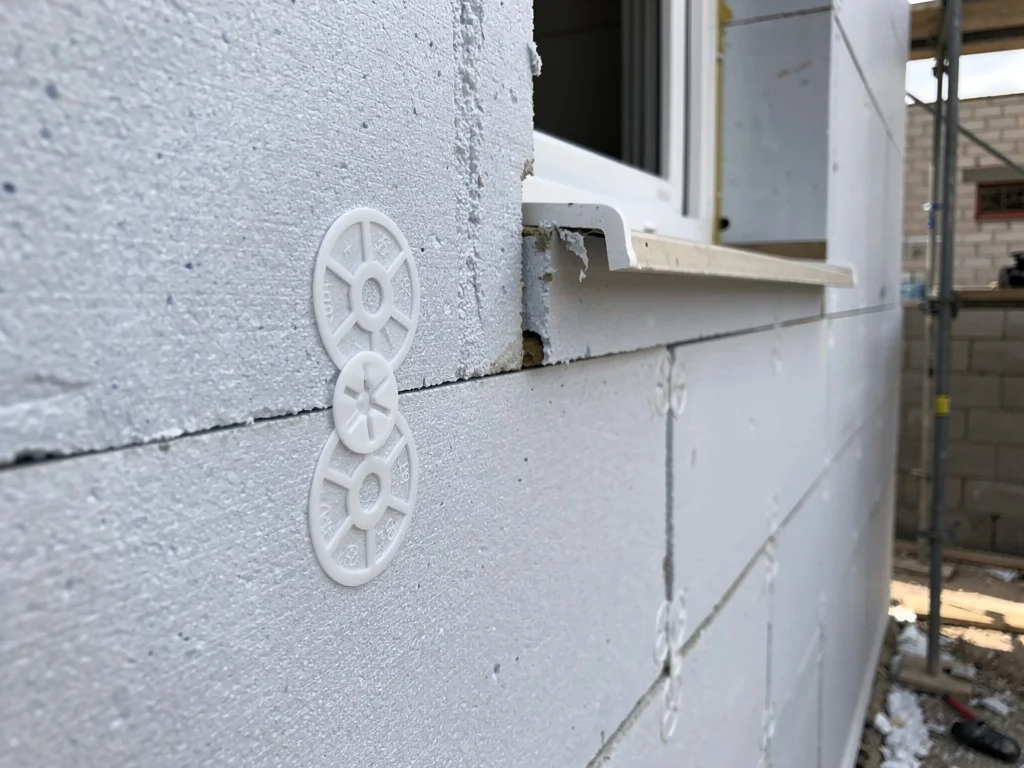 Panneaux isolants collés et chevillés sur un mur avant enduit